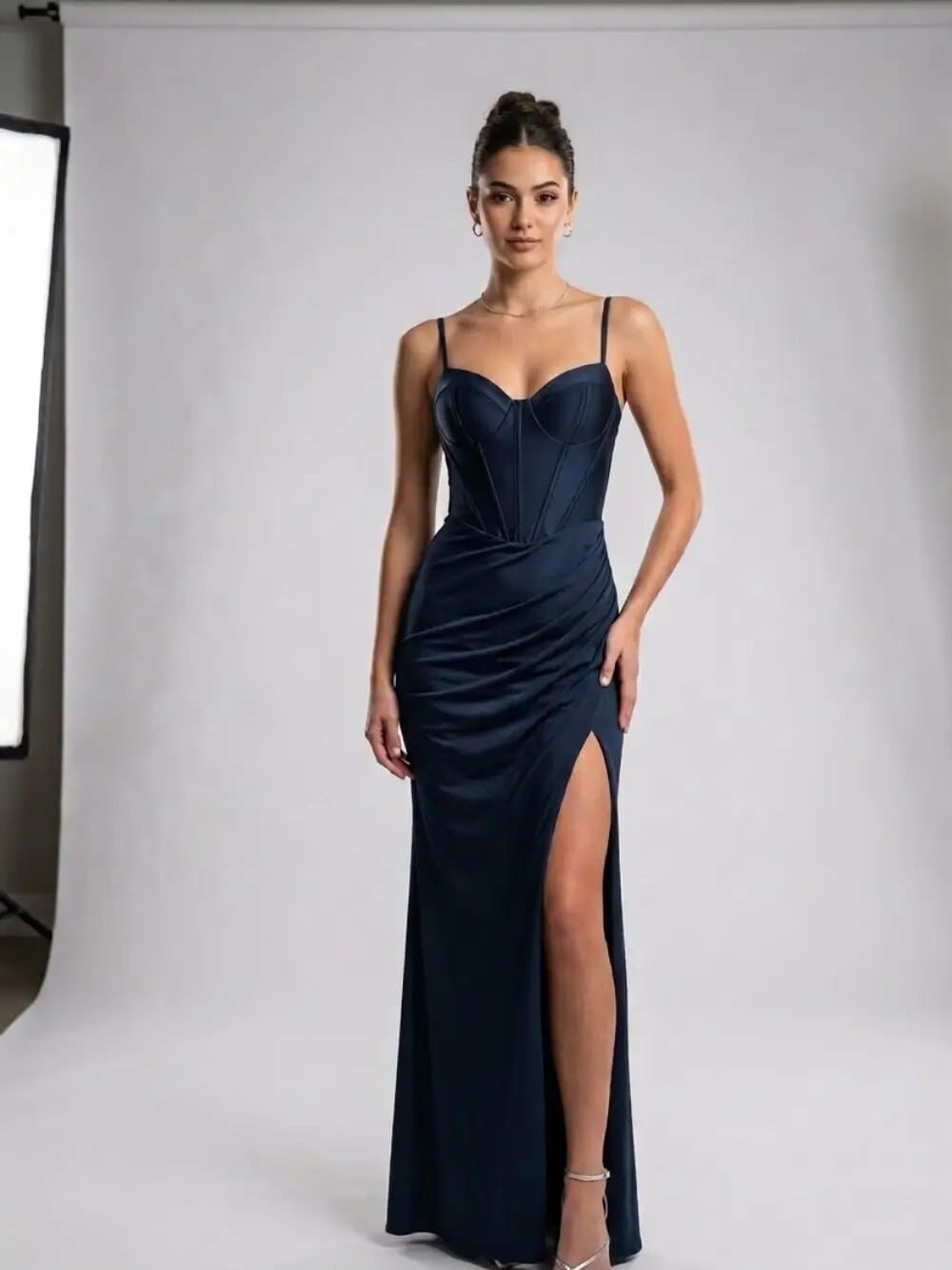 Vestido de gala azul marino de satén con abertura lateral, en estudio