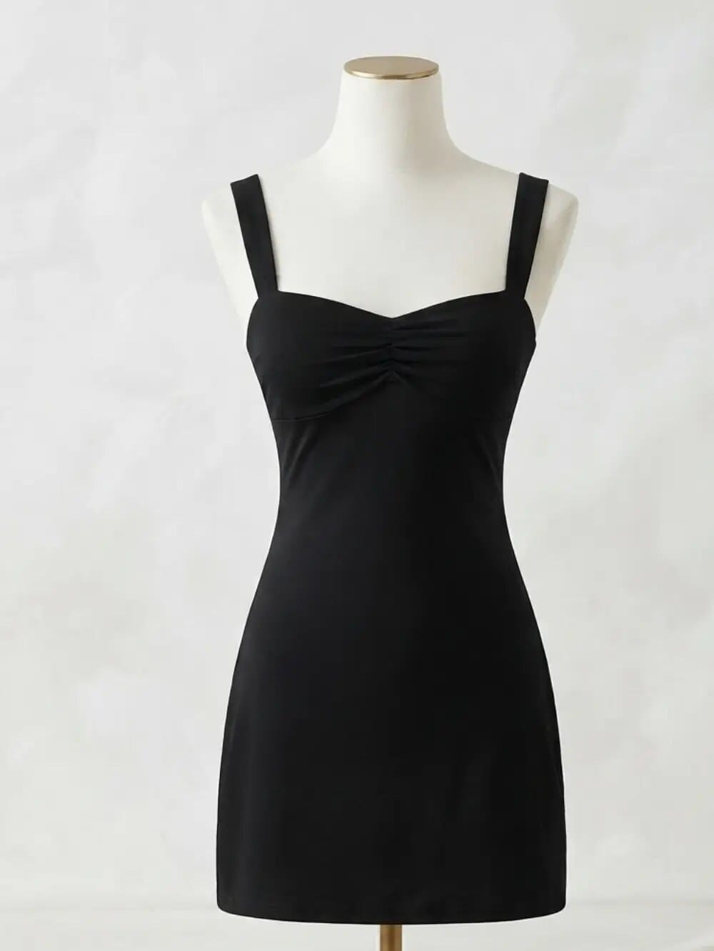 Vestido negro corto de tirantes anchos sobre maniquí